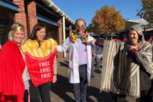 Three staffed dressed up in costumes